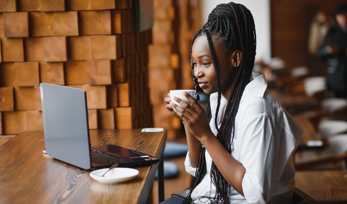 Woman drinking coffee and checking email at a coffee shop
