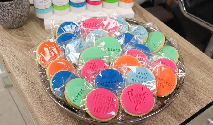 Round cookies with different imprinted phrases like Thank you or Superstar displayed at the reception of a beauty salon