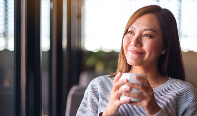 Woman drinking hot coffee and smiling