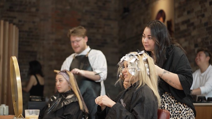 A stylist adding foils to client's hair