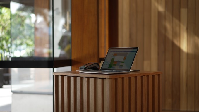 A wooden reception with a laptop on top of it