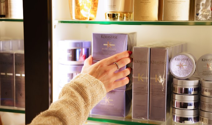 Salon manager grabbing a Kerastase hair care product from a shelf