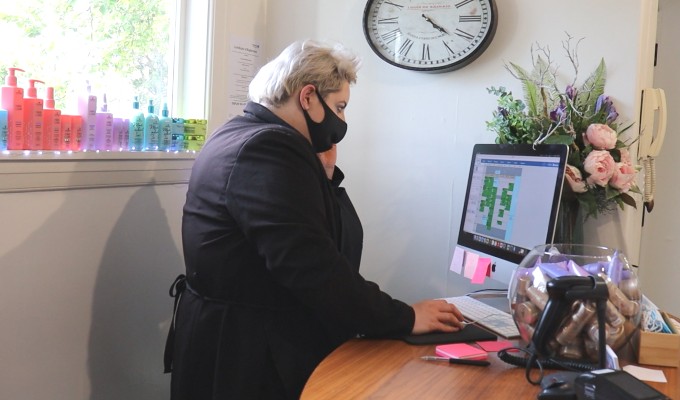 Hairstylist booking an appointment for a client on a computer